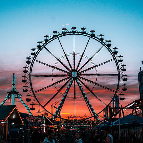 ferris wheel at night with sunset in background