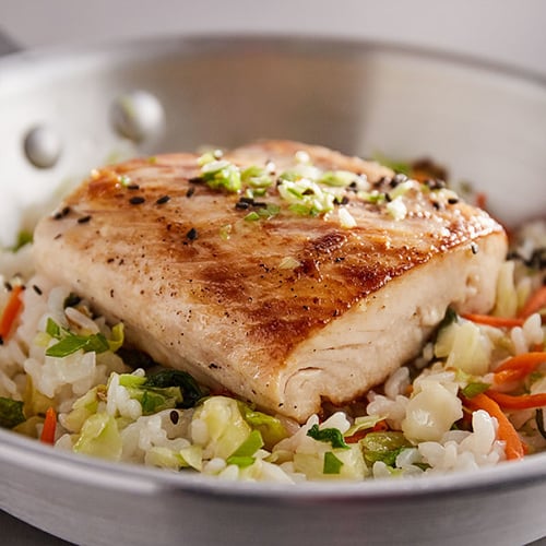 grilled salmon on bed of rice and chopped vegetables