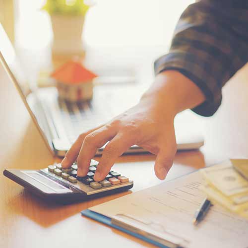 man calculating profits on calculator