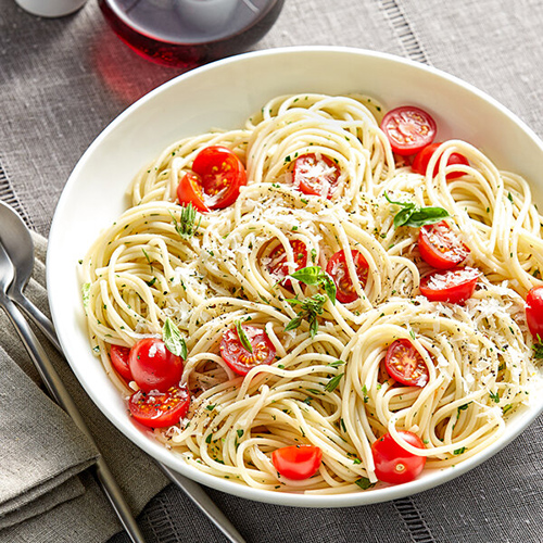 pasta with parmesan and tomatoes in white ceramic bowl