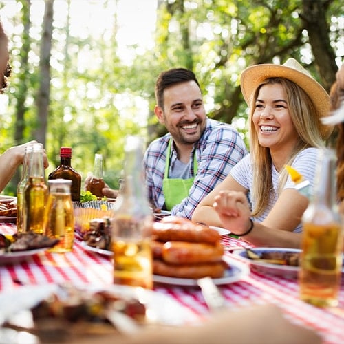 people at a fall themed picnic featuring sausage and beer