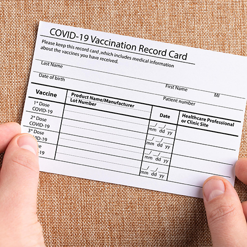 person holding covid vaccination card