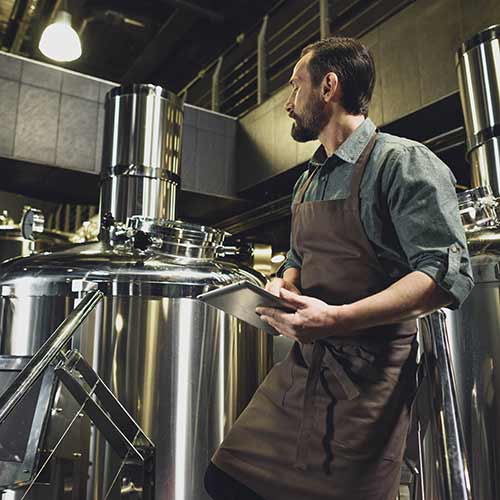 worker inspecting equipment at brewery