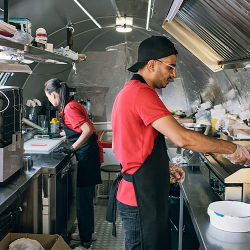staff cooking inside a food truck