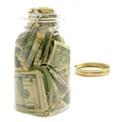 Glass jar filled with money with lid off