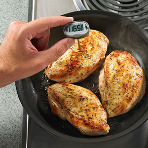 using a probe thermometer in a piece of cooked chicken