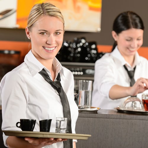 female servers smiling in a cafe