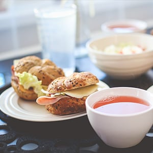 Sandwich à l'assiette sur un petit pain kaiser et une tasse de thé chaud