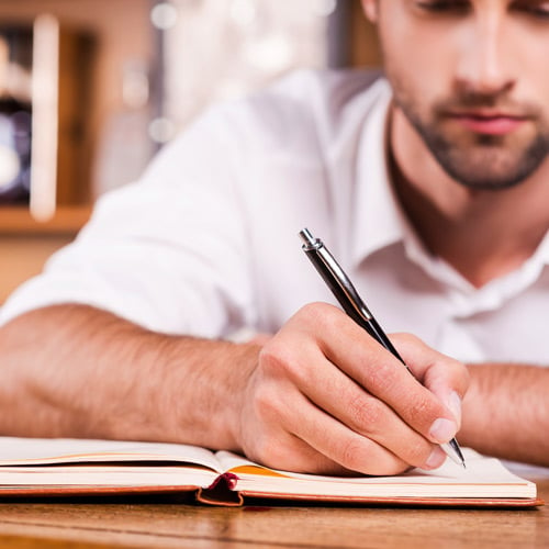 man writing in a notebook