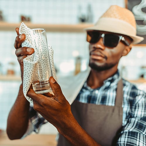 Bartender polishing a cocktail glass