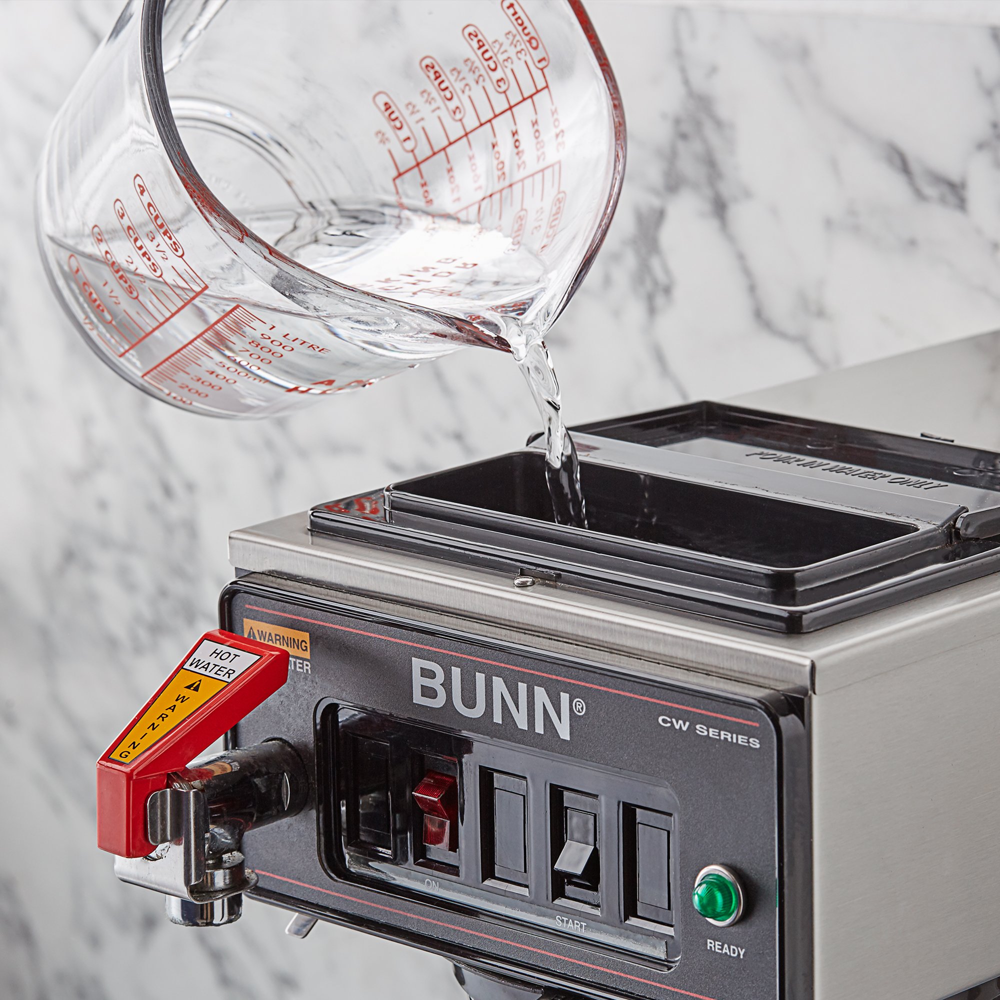 Pouring descaling solution in a Bunn coffee maker