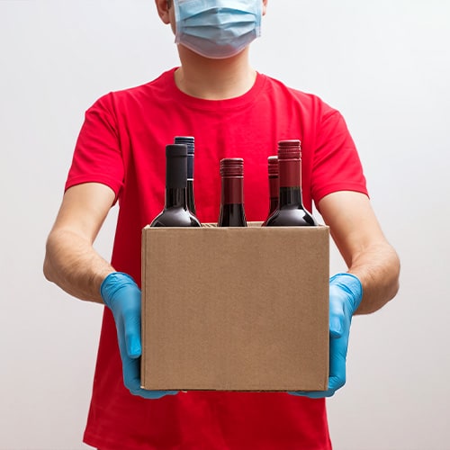 man with mask delivering a wine box