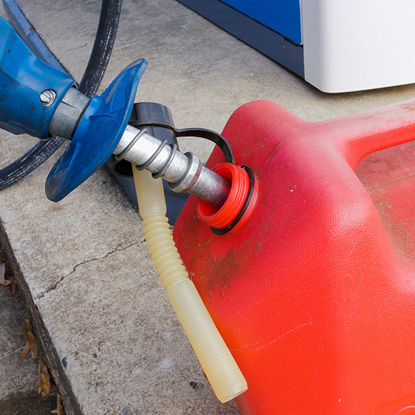 red plastic gas can being filled at gas pump