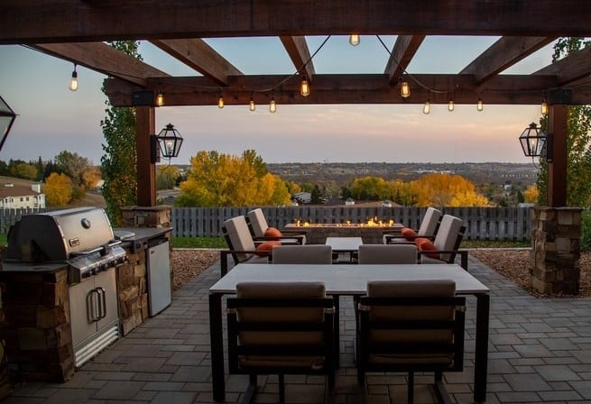 Outdoor patio with outdoor table and chairs and grill under gazebo with fairy lights