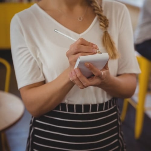 Female server writing on notepad